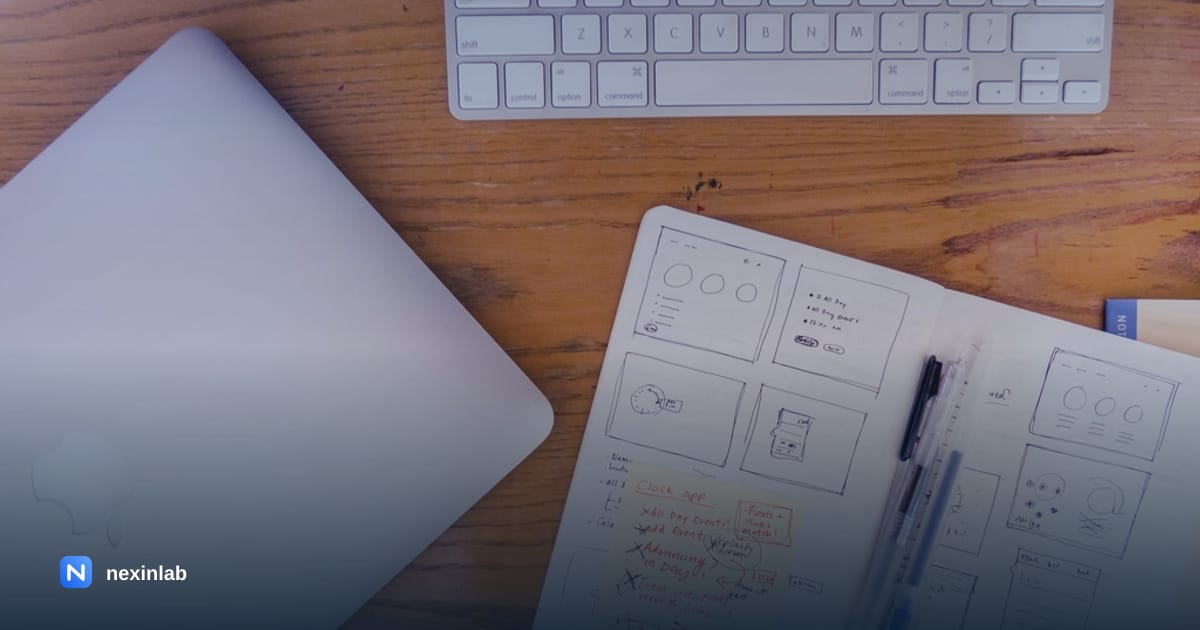 Photo: website wireframe sketches in a notebook on a desk next to a laptop
